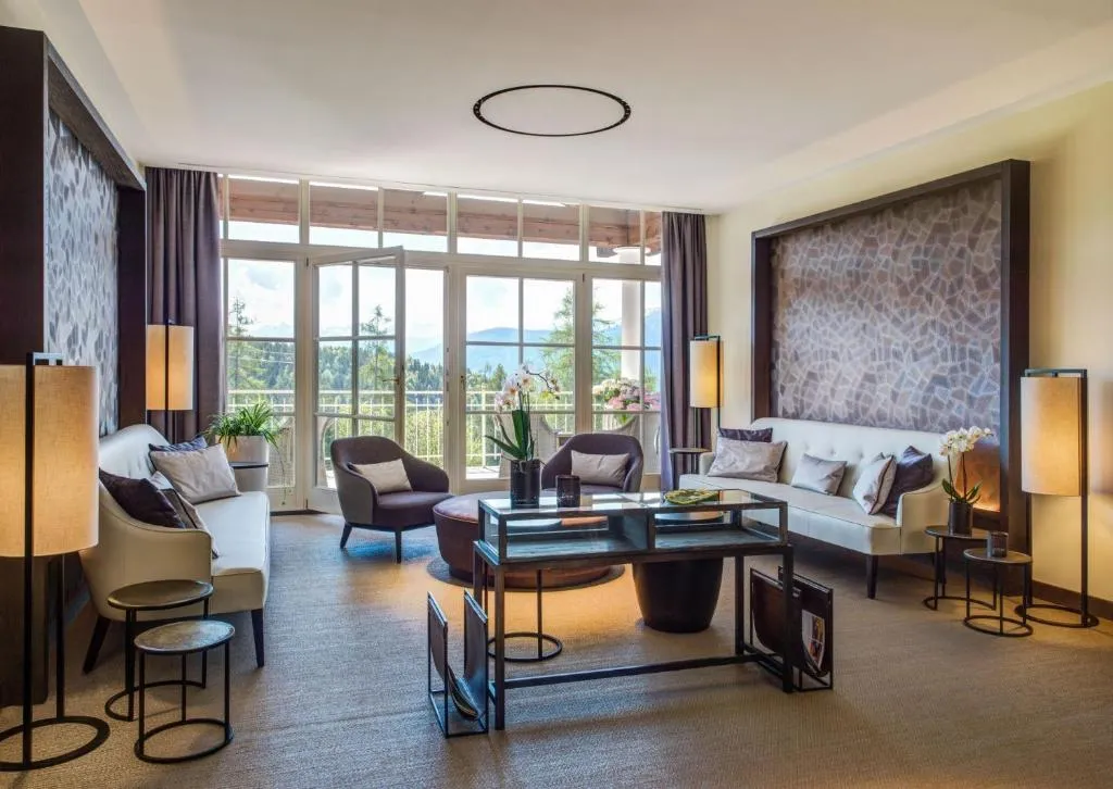 sala lujosa con balcón privado en el Interalpen-Hotel Tyrol en australia, donde podrás contemplar impresionantes vistas panorámicas de la ciudad. Este exclusivo hotel ofrece una experiencia de lujo.