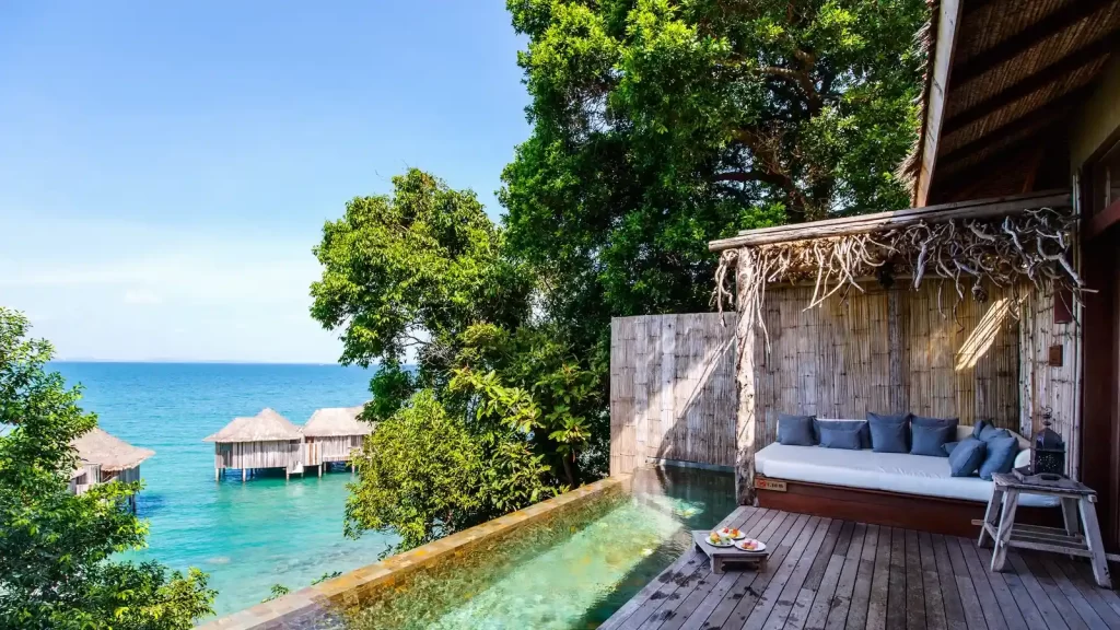 asiento cómodo con cojines gris y una piscina con vista al mar para que puedes disfrutar del un desayuno