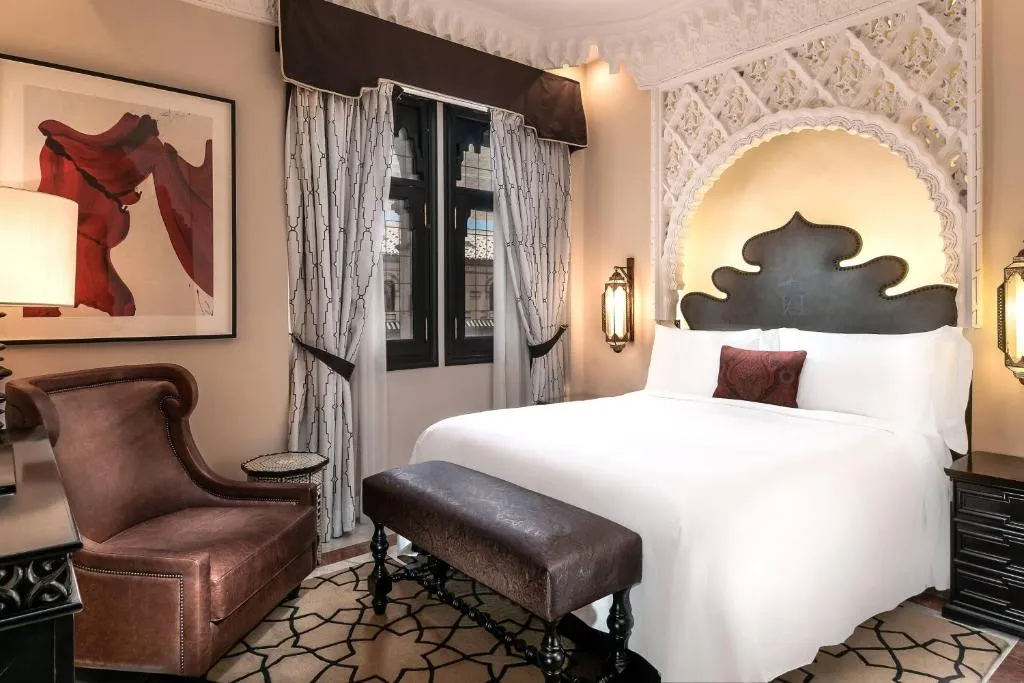 Una habitación acogedora con cama para dos, un cómodo sillón y una ventana que aporta luz natural y vistas al exterior.