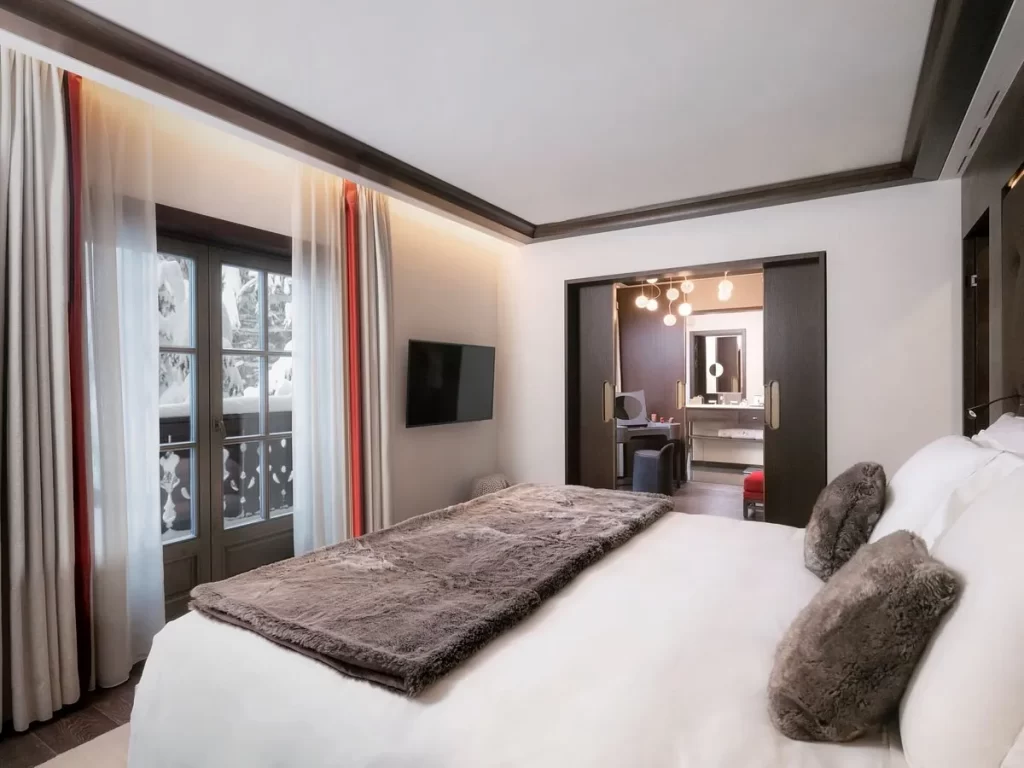 habitación de lujo con tocador y ventana donde puedes salir al balcón y disfrutar de una agradable vista a la ciudad.