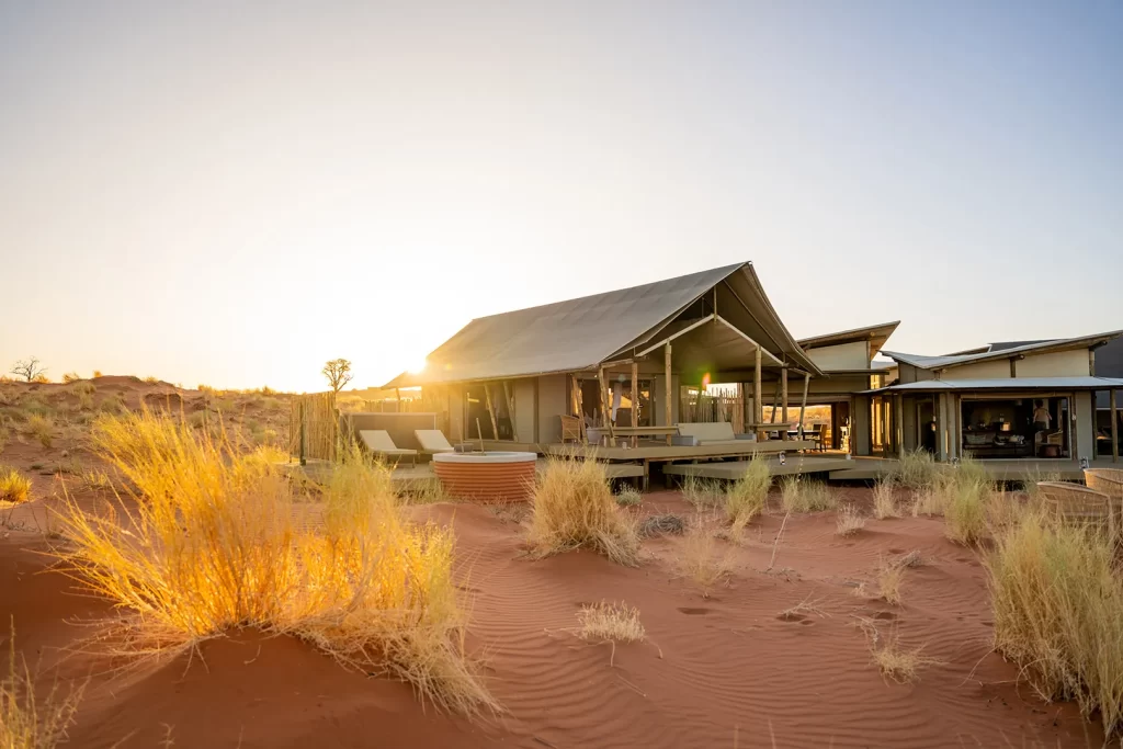 turista alojada en un albergue con un amplio espacio donde va poder sentarse y mirar el desierto en la noche.