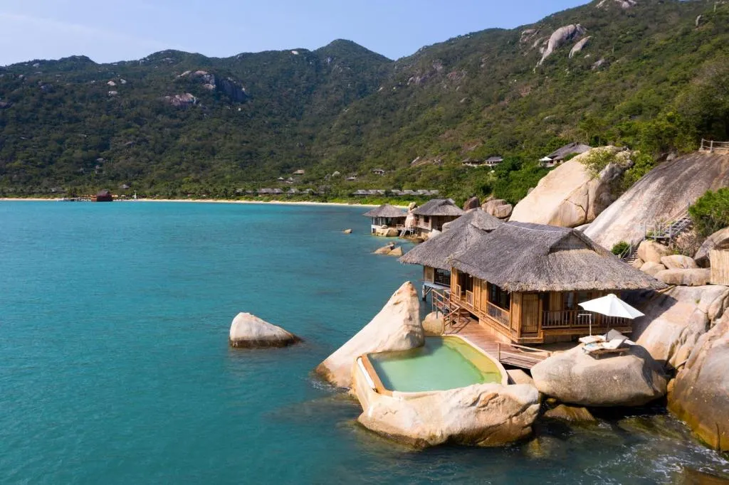 habitación alojada en una parte rocosa con vista al mar y una piscina