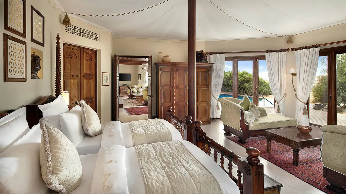 habitación grande con dos camas individuales, sala y balcón con piscina privada.