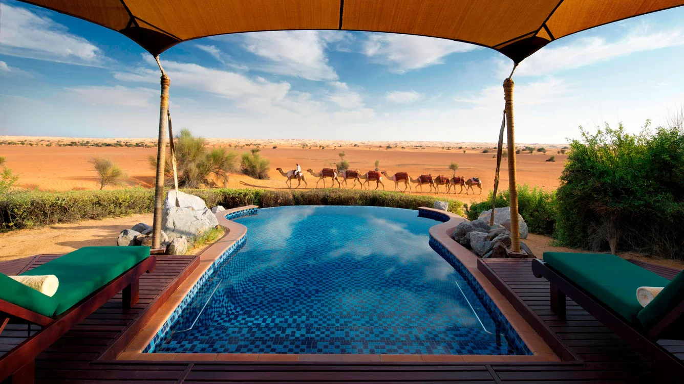 piscina con sillas cómodas al rededor donde puedes disfrutar de una increíble vista al desierto donde veras pasar los camellos.