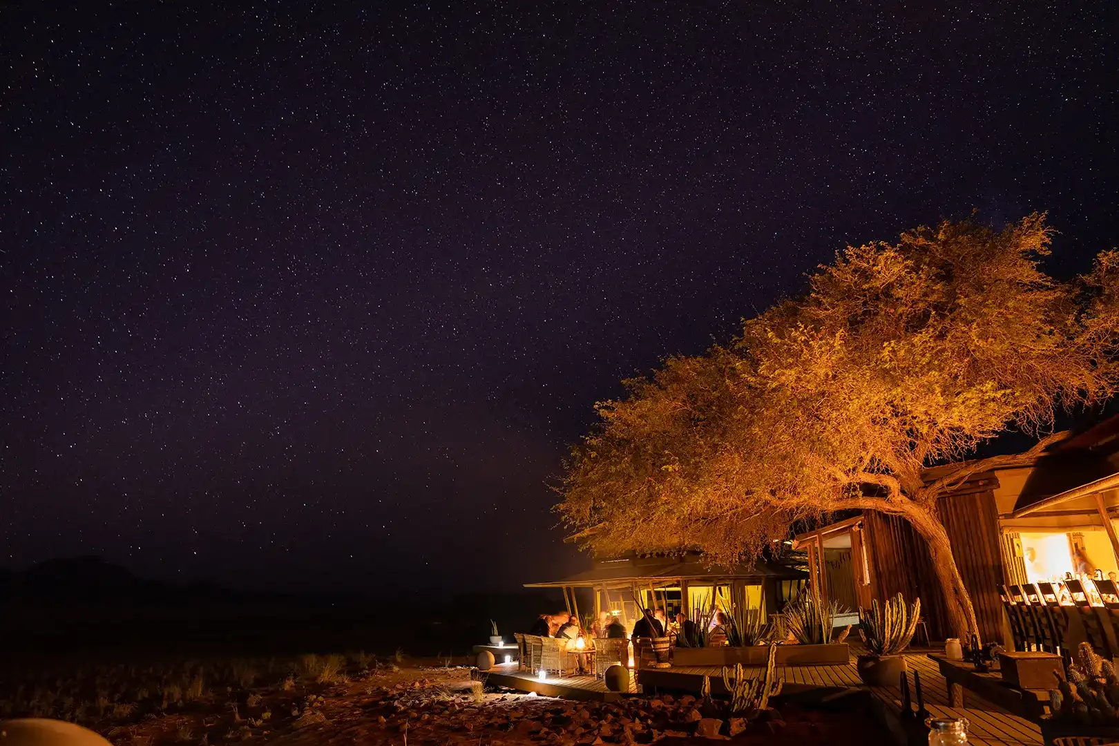 turistas disfrutando de una cena en el restaurante al aire libre en la noche en las Dunas de Wolwedans