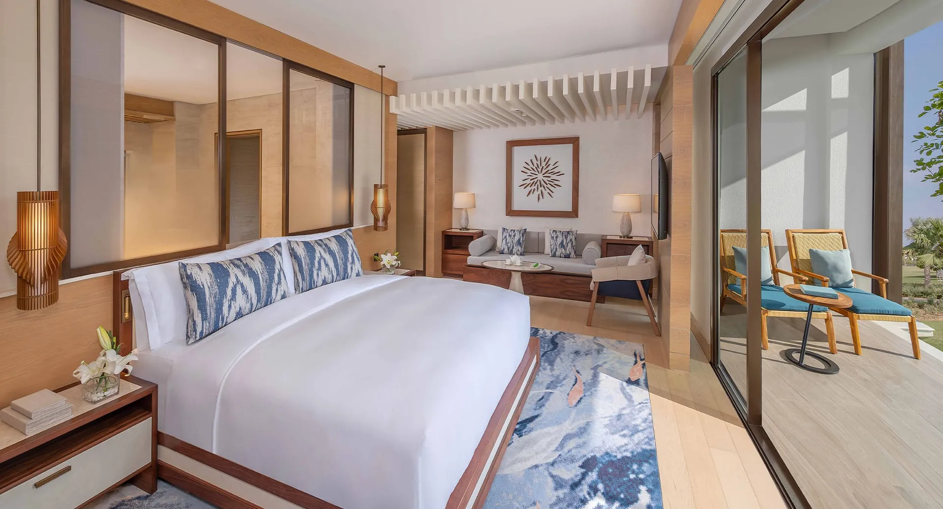 habitación de lujo con cama para dos personas con sala, buena iluminación y un balcón con una increíble vista.