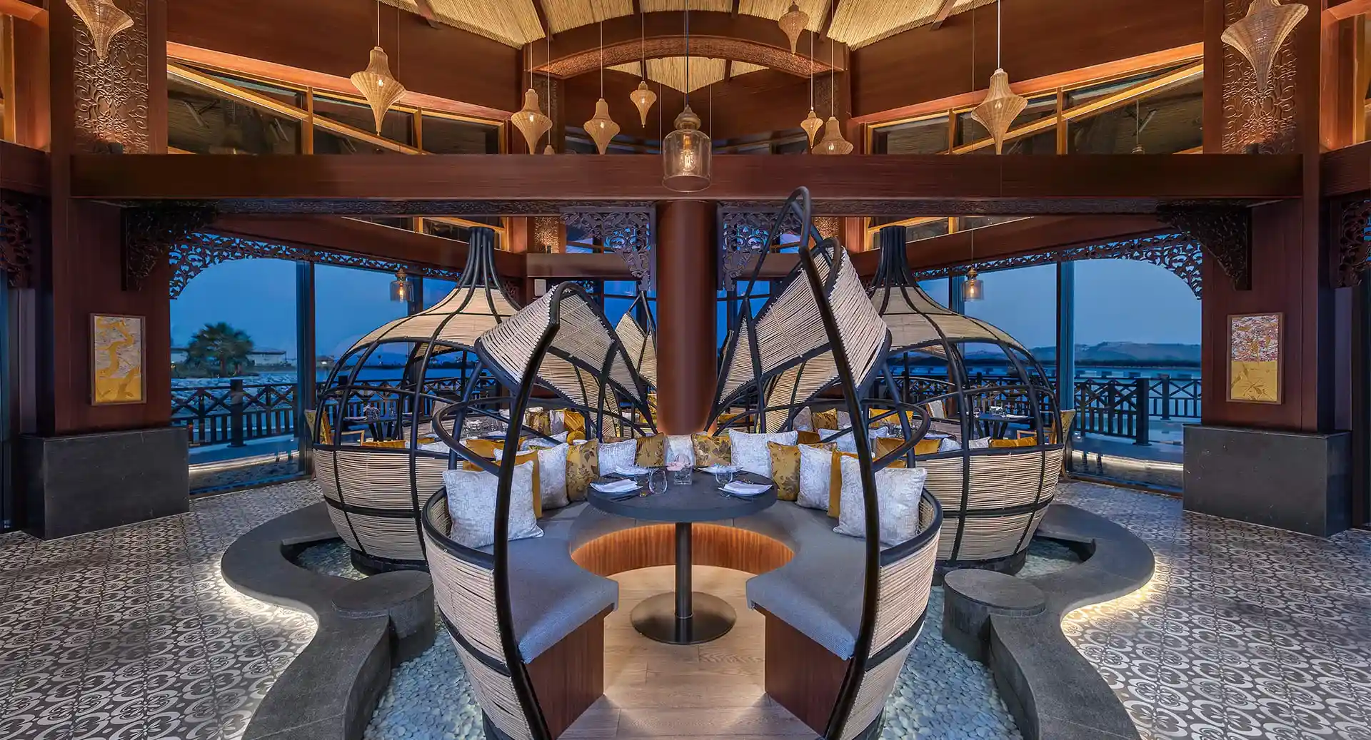 restaurante lujoso con sillas de forma arqueada con cojines y mesa para disfrutar de la gastronomía en anantara