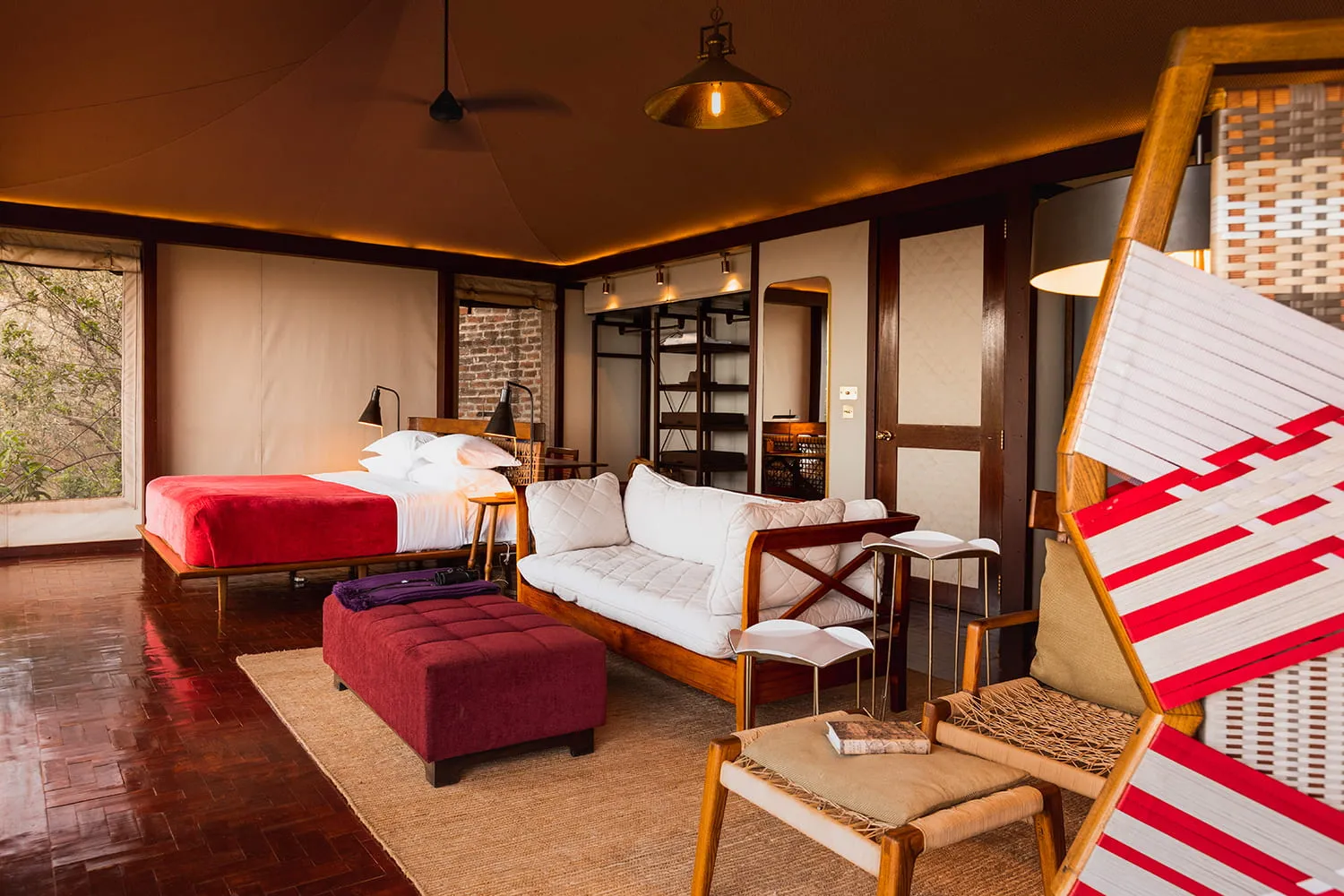 habitación amplia con una cama para dos personas un sillón y asientos para que puedas leer en un lugar cómodo