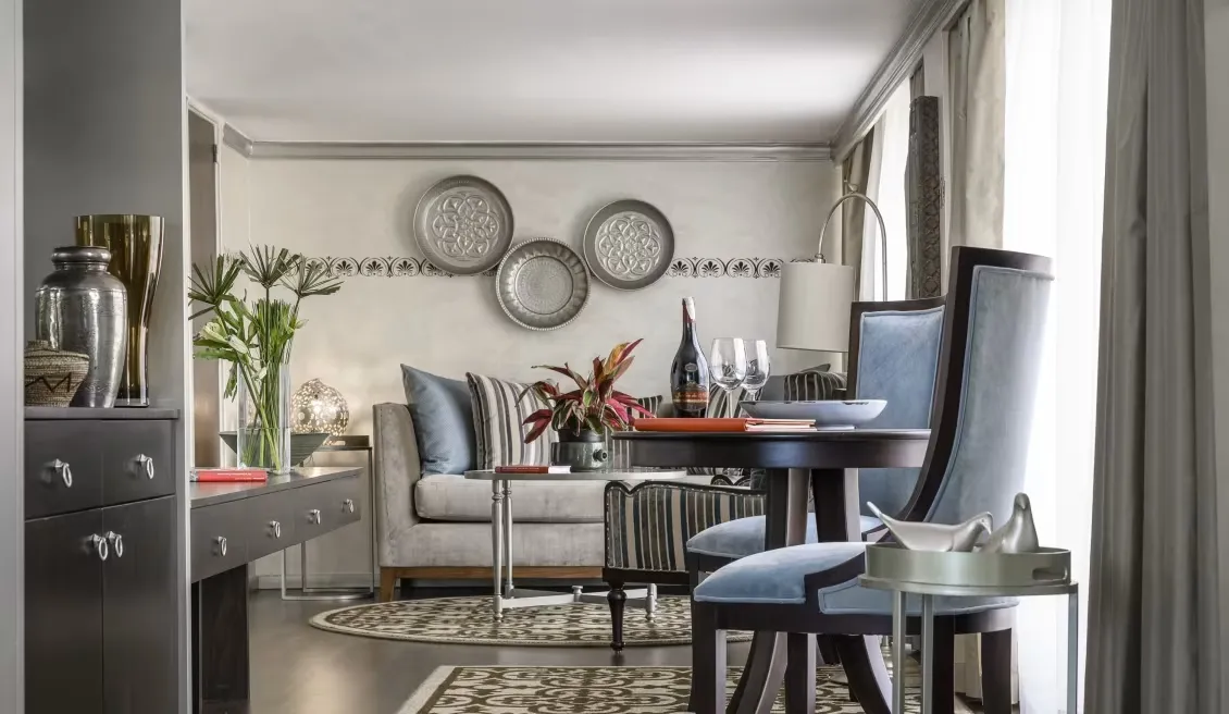suite con sala de estar, un sofá suave, una mesa decorativa de y una mesa con dos sillas, encontrarás dos copas de vino y tendrás algo para leer