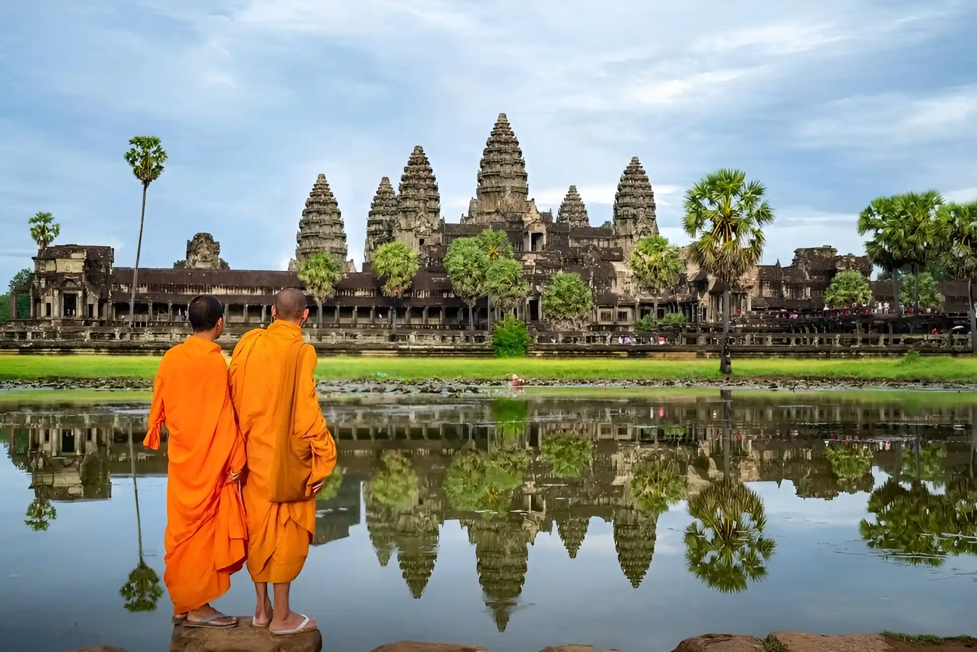 monjes parados en una piedra viendo el antiguo templo de camboya