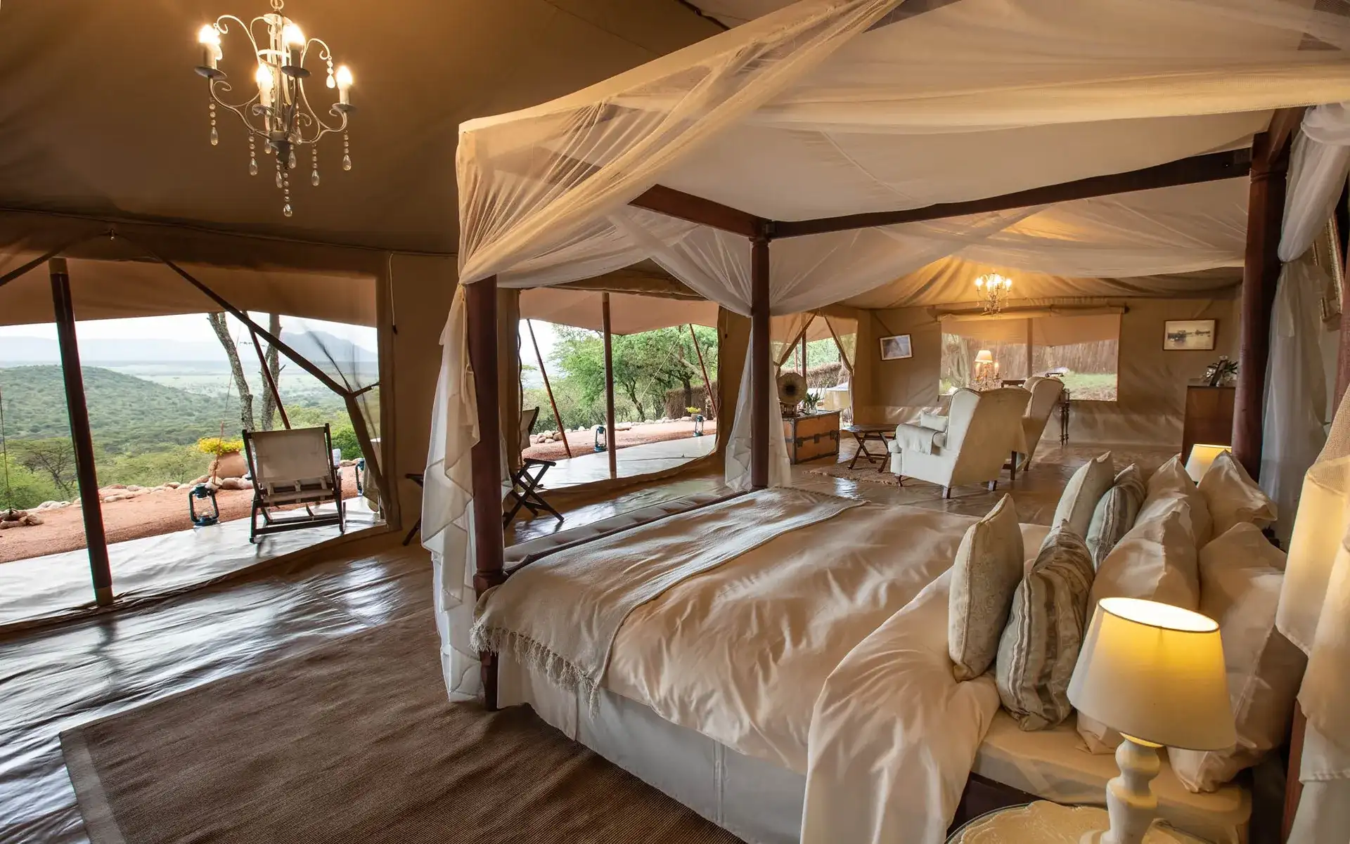habitación grande con cama para dos personas asientos y ventanales para salir al balcón