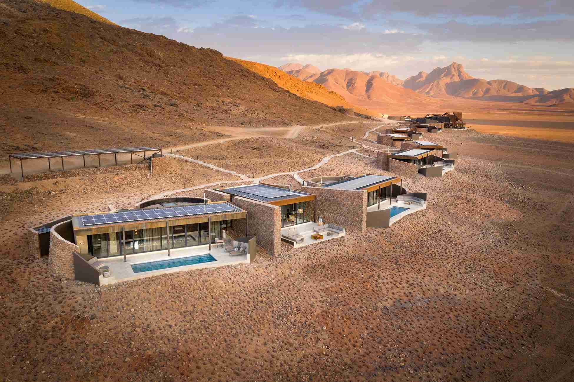habitaciones de lujo cada uno cuenta en la parte de afuera con sillas, mesas y una piscina para una cómoda estadía donde tus vacaciones serán posibles con journale .
