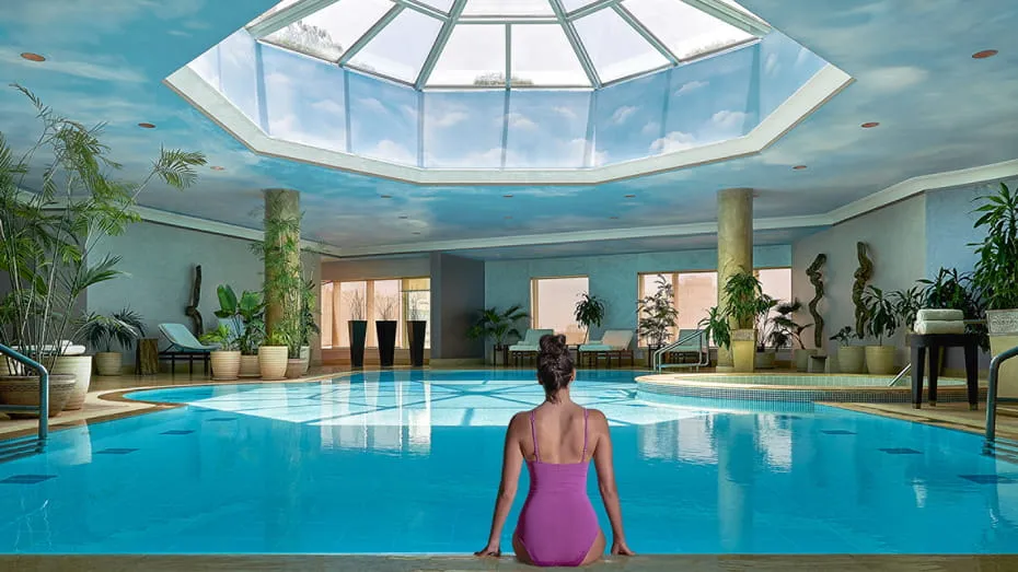 turista en en la zona de piscina, rodeado de sillas cómodas y plantas creando un ambiente relajante.
