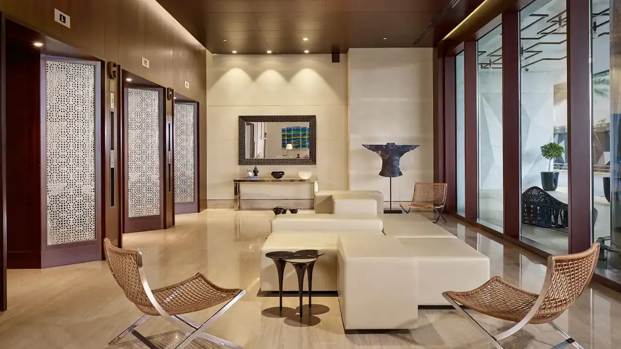 Relájate en una sala de espera de lujo diseñada con elegancia, que cuenta con un amplio ventanal con vista panorámica a la ciudad. Ideal para disfrutar de un ambiente exclusivo mientras esperas en total comodidad.