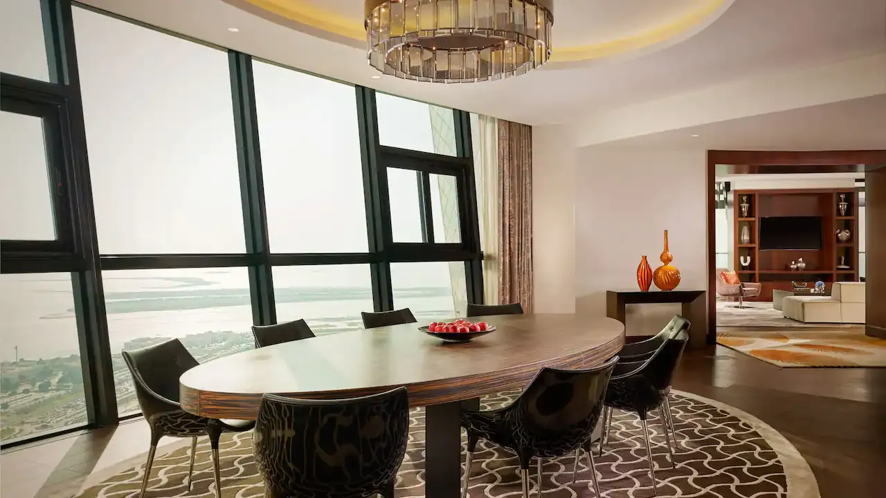 suite con comedor de lujo, diseñada con elegancia. Disfruta de un amplio ventanal que ofrece una espectacular vista tanto a la ciudad como al mar, creando un ambiente perfecto para una estancia inolvidable.