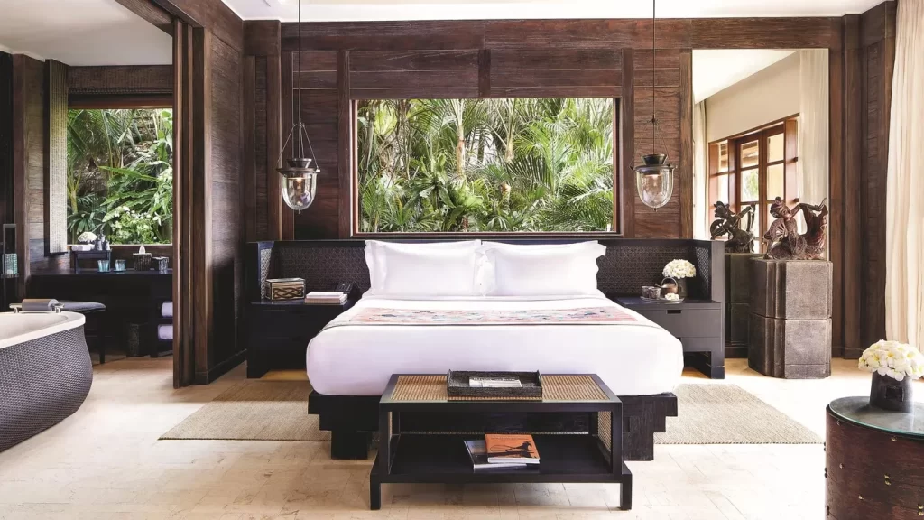 habitación amplia con detalles de madera, una cama para dos personas, una mesa decorativa y una tina.