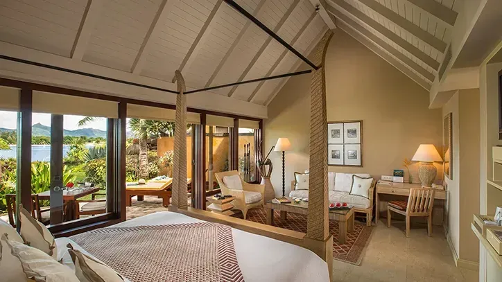habitación con una cama para dos personas, un escritorio para leer, una sala para relajarte y una vista de la isla desde el balcón