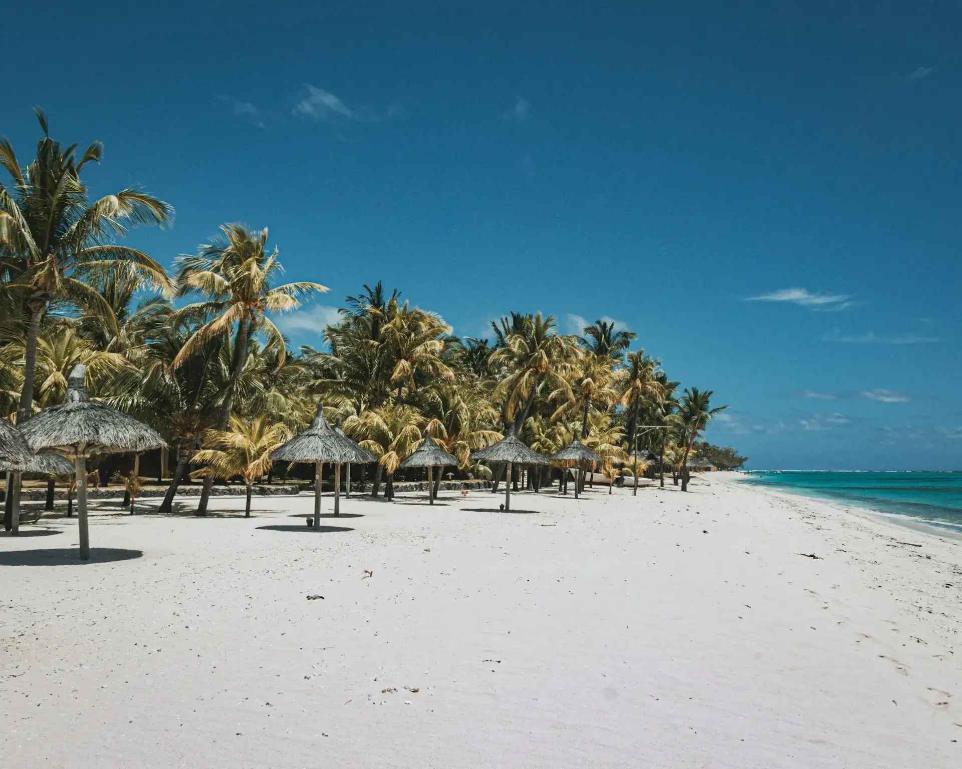 playa islas Mauricio donde puedes relajarte bajo una sobrilla de madera y paja con vista al mar