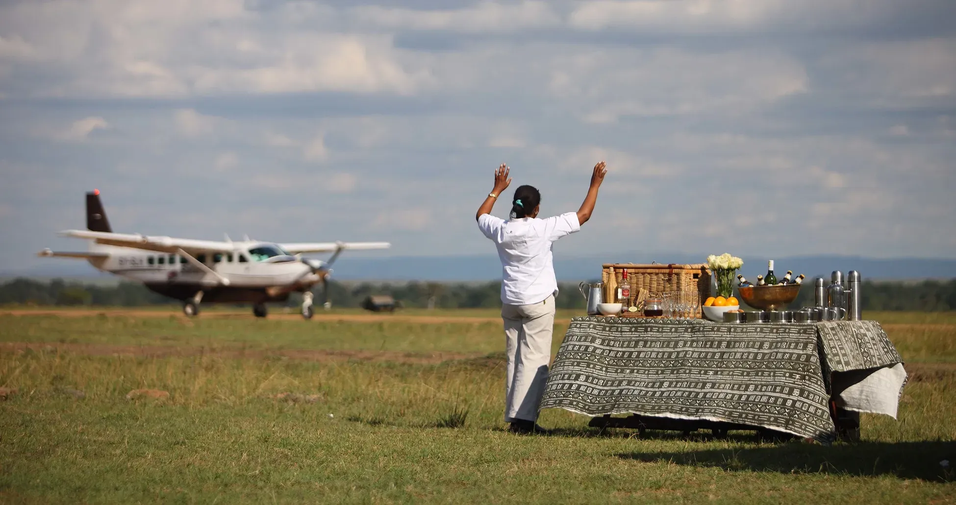 avioneta aterrizando en uno de los lugares en kenya donde van a recibir a las personas con una bebida