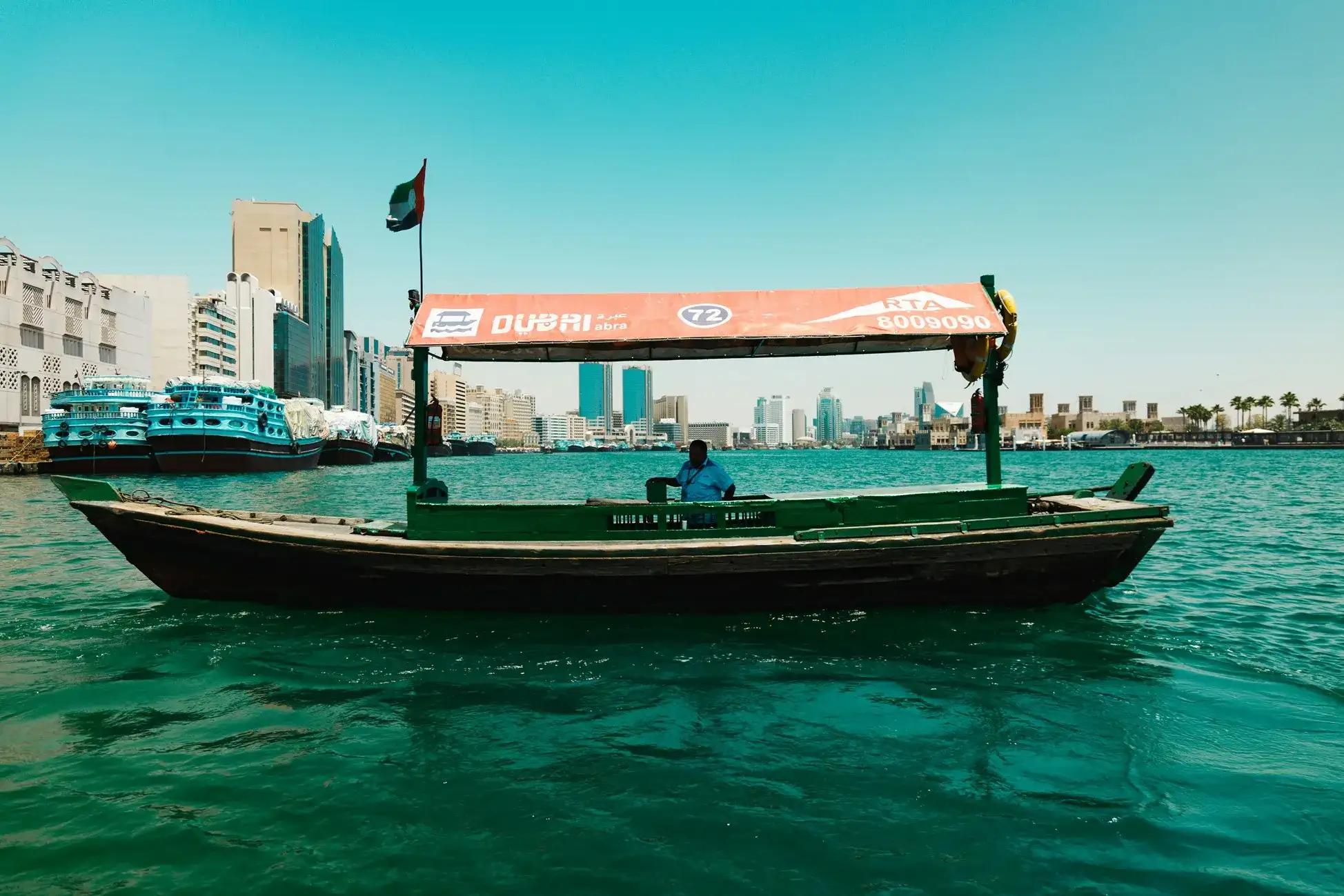 persona navegando en una lancha en el mar de Dubái con vista de los altos edificios