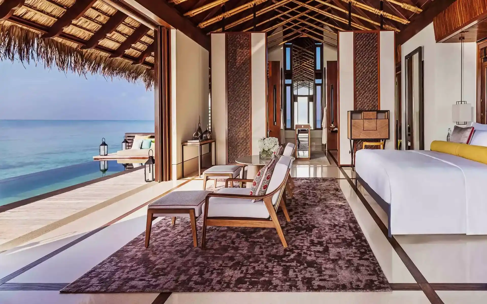 habitación de lujo con cama para dos personas, con sala y un ventanal grande donde se puede ver una espectacular vista al mar