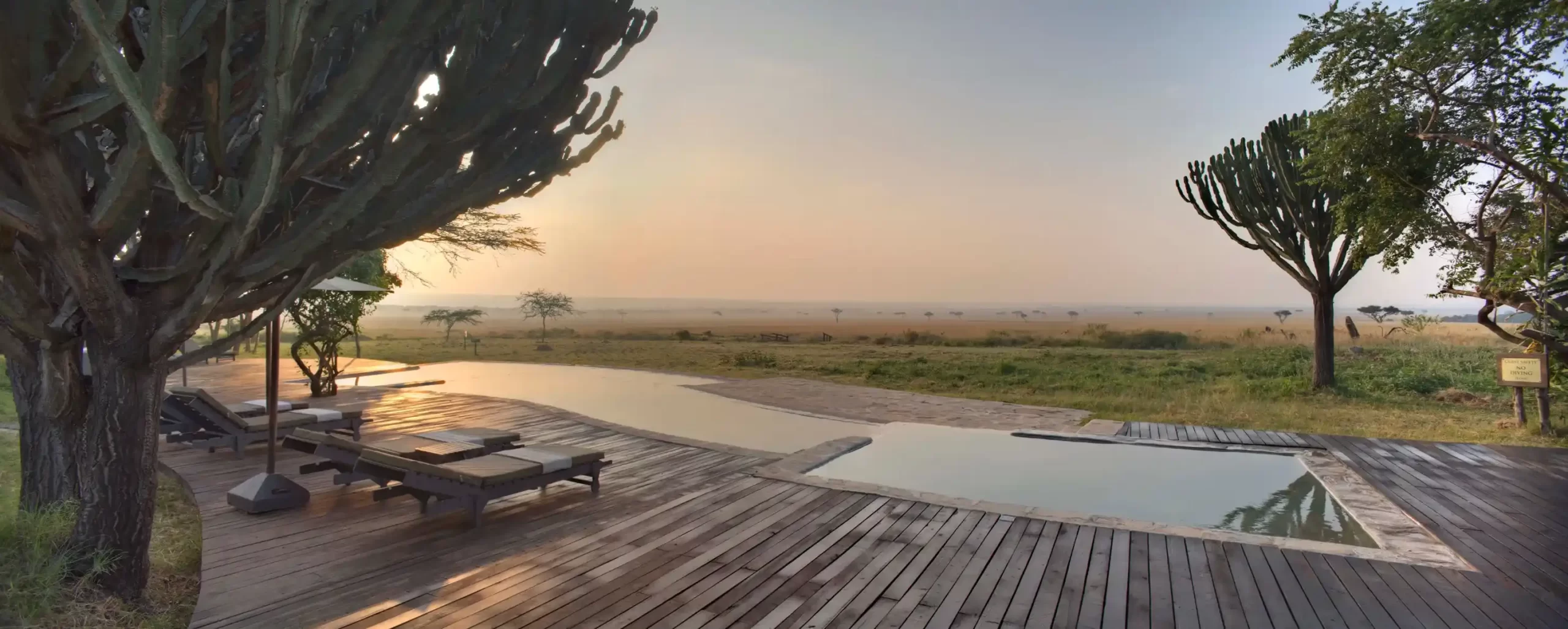 piscina con sillas de madera a su alrededor y una gran vista donde vas a poder relajarte