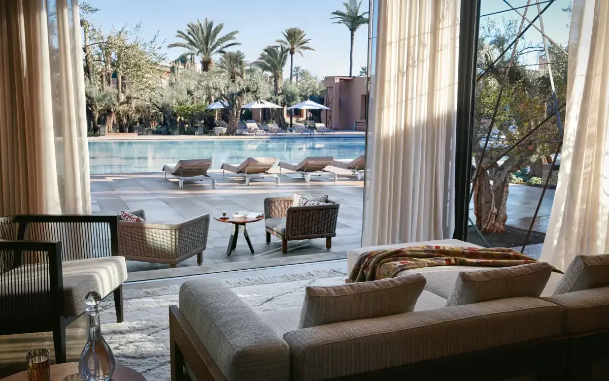 habitación con sillones y un ventanal grande para salir afuera y disfrutar de la piscina y de la zona verde