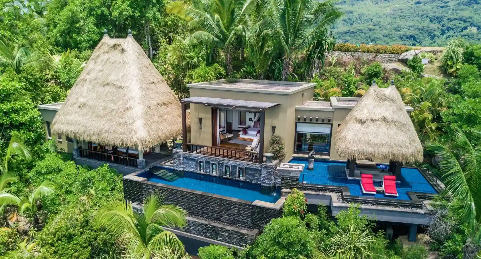 lujosa villa con cama para pareja, balcón con piscina y sillas cómodas