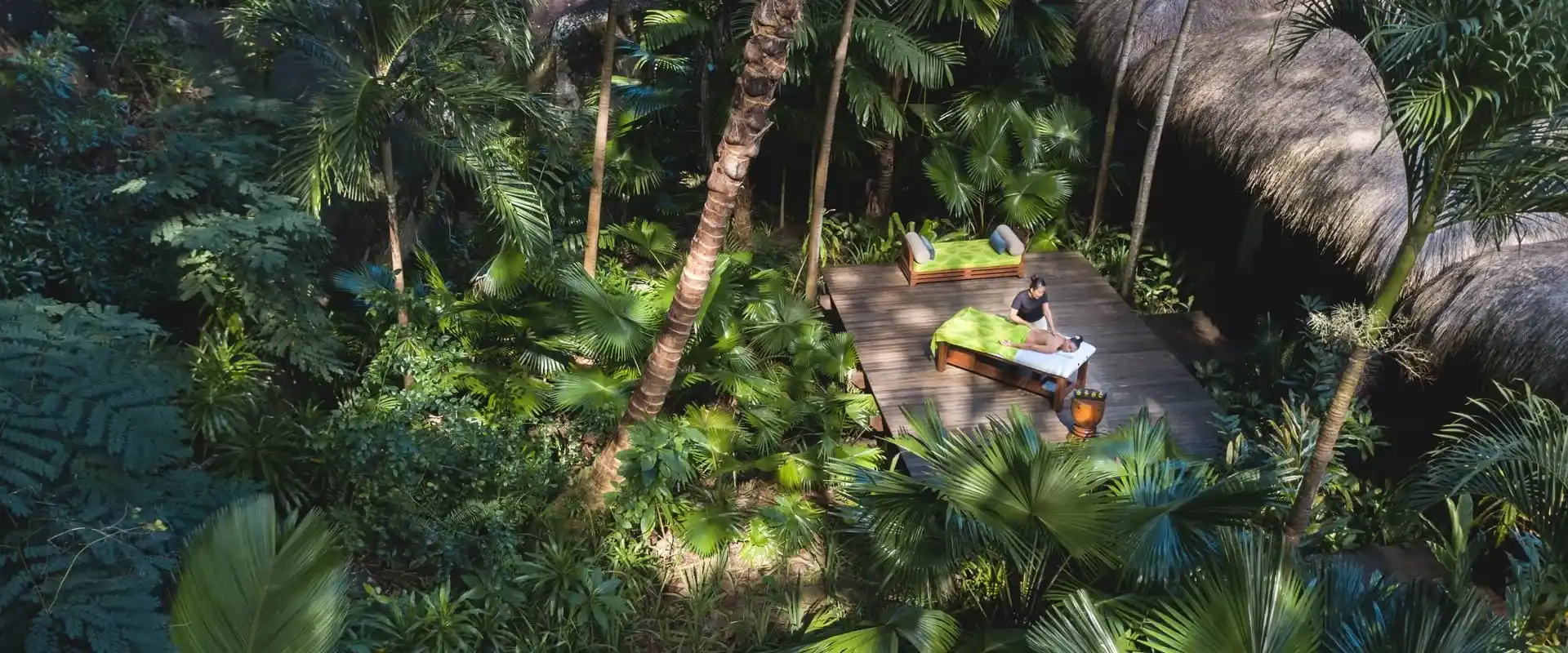 turista disfrutando de un masaje relajante al aire libre, con vista a la naturaleza con arboles y plantas