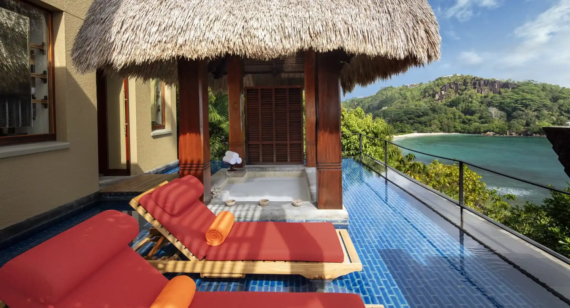 balcón con piscina y silla de madera para tomar un descanso en un ambiente relajante mientras se observa la vista al mar