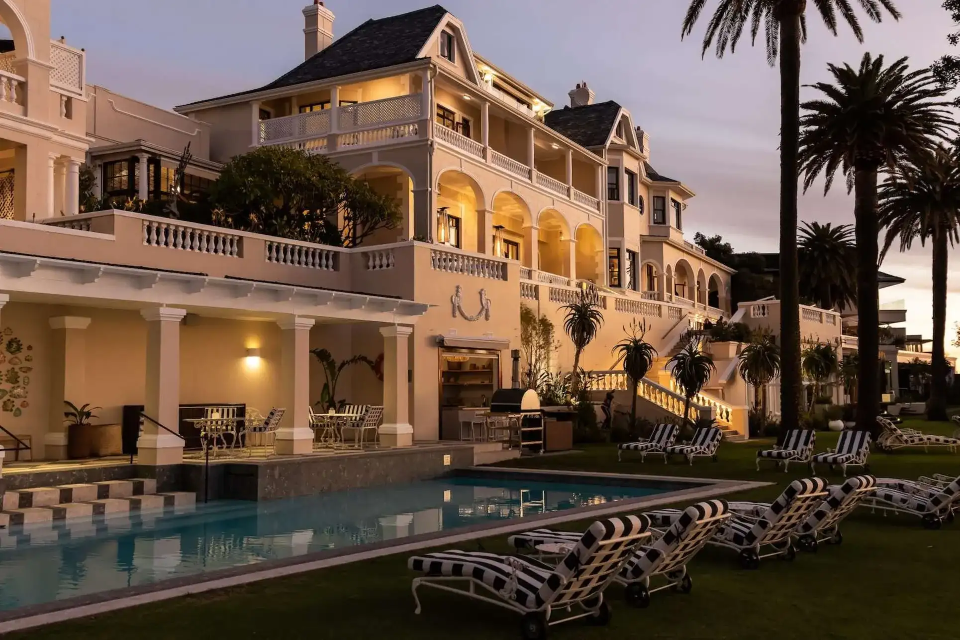 piscina al aire libre con sillas cómodas para relajarse y con vista del hotel de lujo