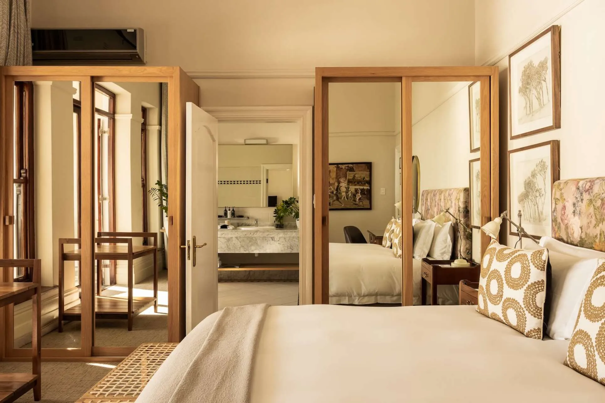 habitación moderna con cama para dos personas, armarios que en la puerta tienes espejo y un lujoso baño.