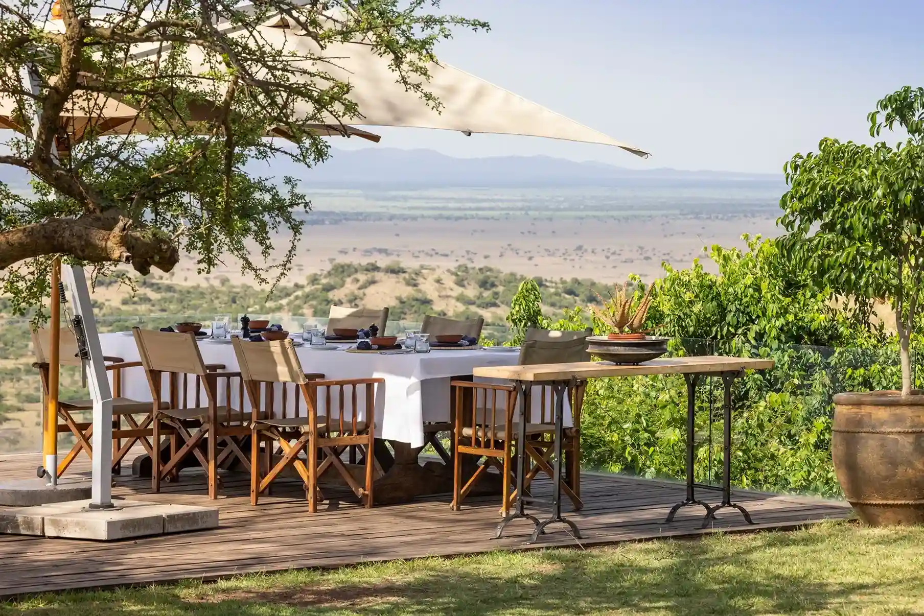 comedor en la sombra rodeado de arboles y plantas donde los turistas van a poder disfrutar del desayuno con vista al safari