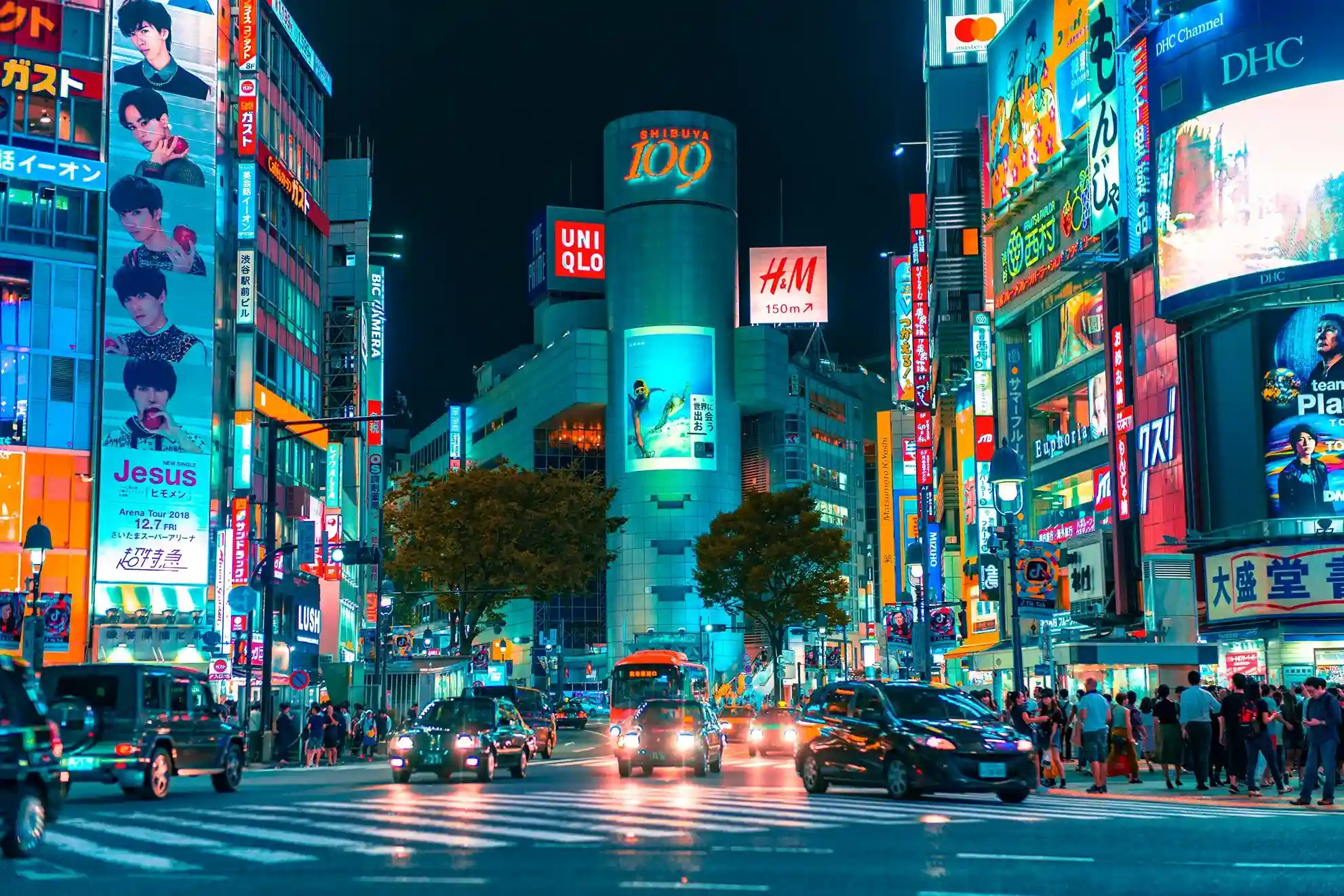 personas caminando de noche en la ciudad de Tokio donde vas a poder disfrutar de su cultura.