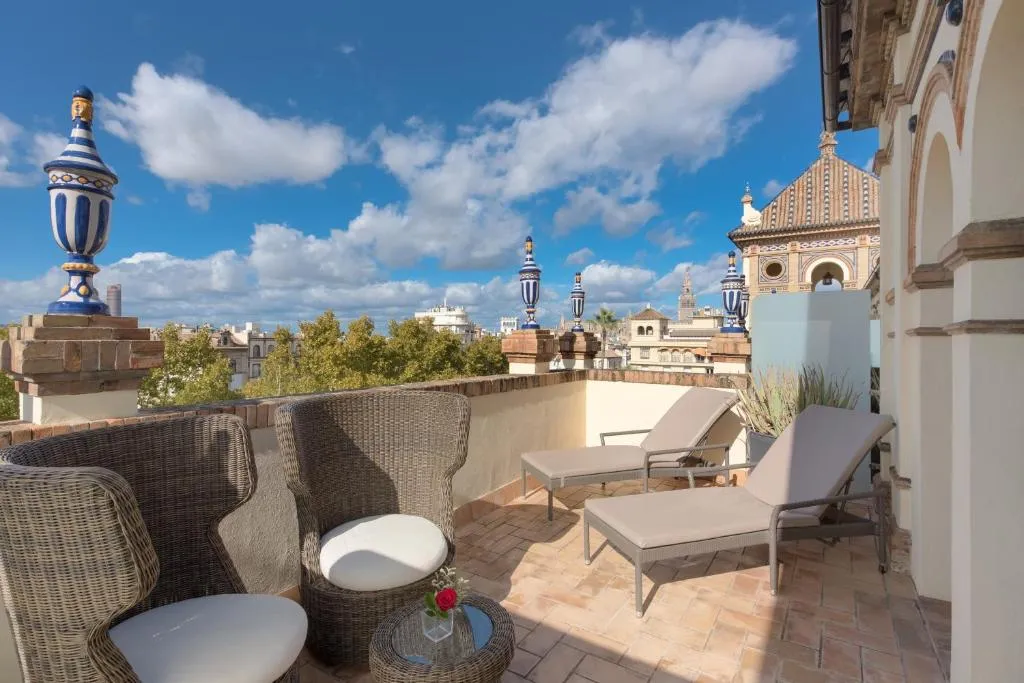 Balcón en el Hotel Alfonso XIII, con sillas cómodas para relajarse mientras disfrutas de las vistas. El ambiente es tranquilo.