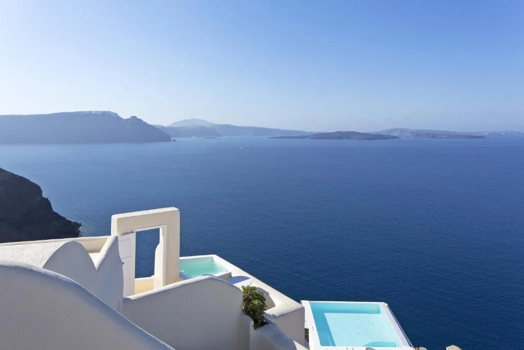 piscina privada de agua cristalina en las suites con vista al mar en Santorini.