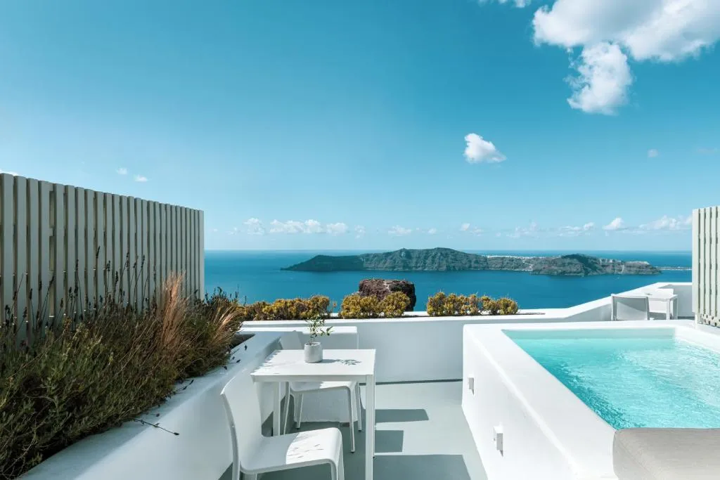 piscina en una de las suite rodeada de jardines, con vista al mar y a las montañas en Santorini.