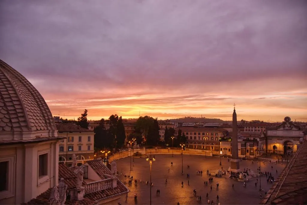 personas caminando en las calles cerca al hotel de russie en el atardecer donde disfrutaras de un clima agradable.