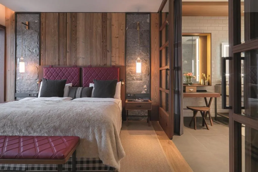 lujosa habitación del Interalpen-Hotel Tyrol, equipada con una cama para dos personas y un elegante baño. Diseñada para ofrecer confort y estilo, es el lugar perfecto para disfrutar de una estancia inolvidable.