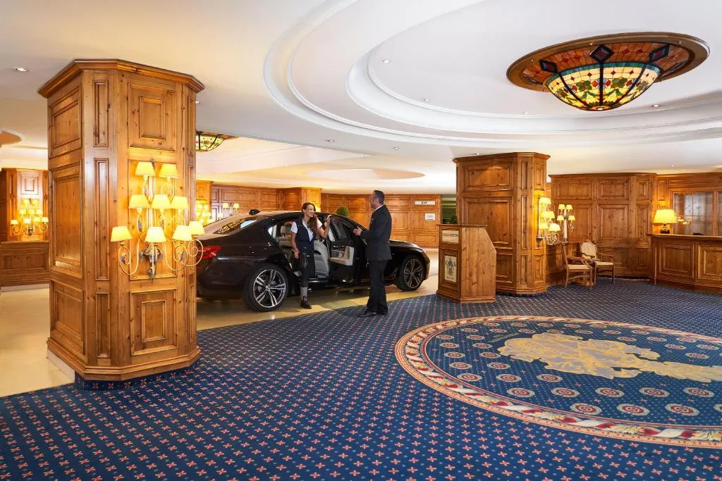 personal del hotel da la bienvenida a una turista abriéndole la puerta del coche. Un servicio atento y exclusivo que marca el inicio de una estancia de lujo.