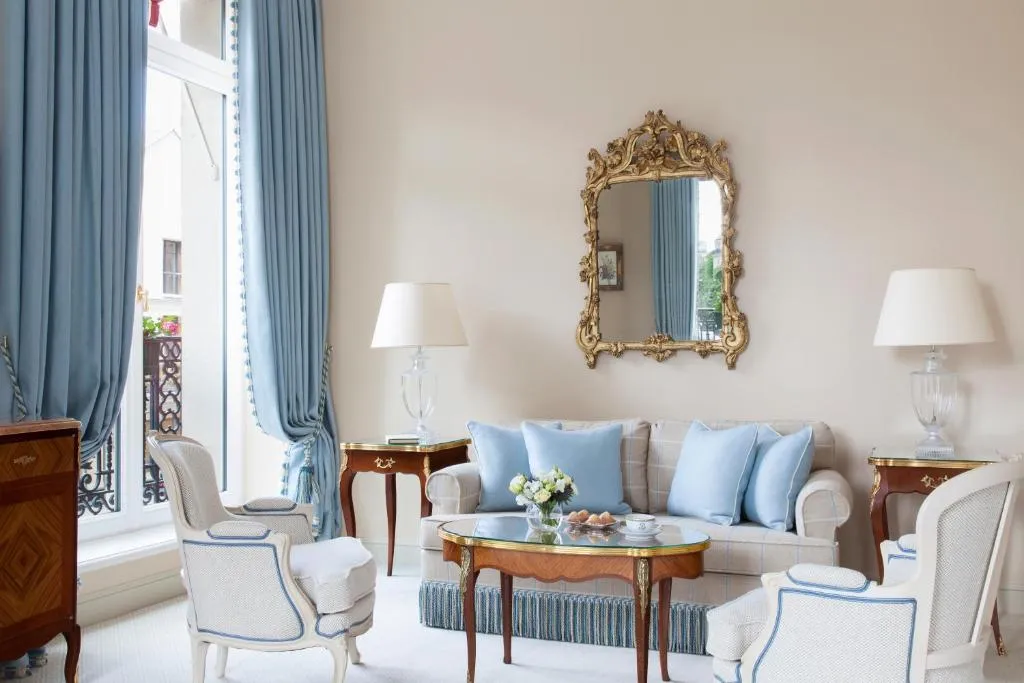 sala con cojines azules y un ventanal con balcón prefecto para disfrutar de una increíble vista de la ciudad desde la comodidad de tu habitación.