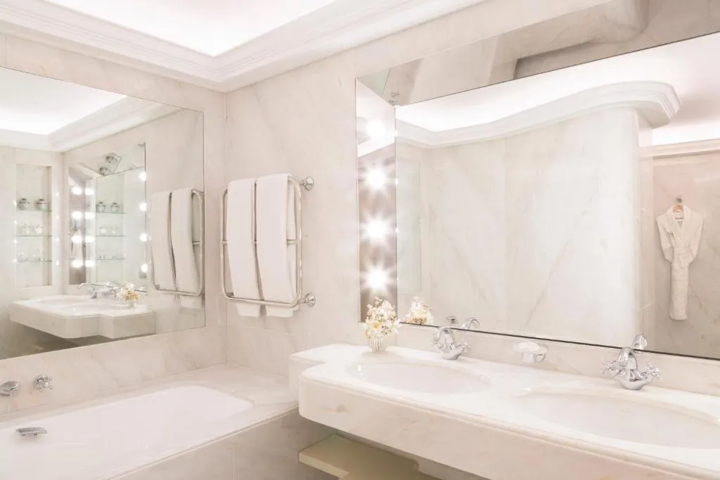 tina de color blanco con un diseño de lujo, con espejo grande para que puedas relajarte en tu estadía en el hotel