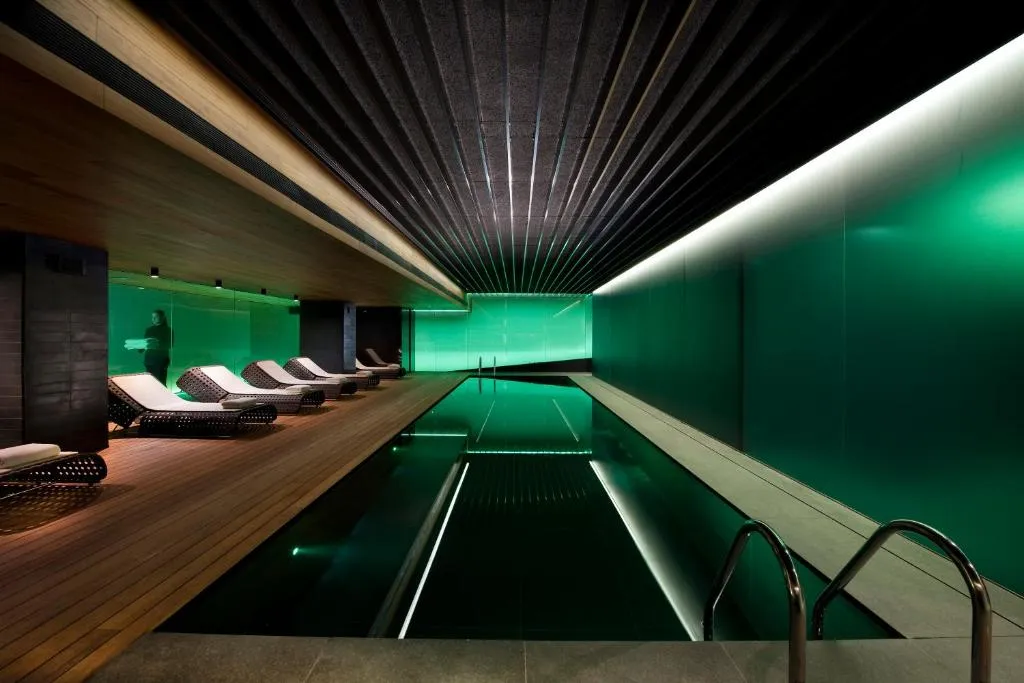 Zona de piscina en el Mandarín Oriental, Barcelona, con sillas cómodas para relajarse. El ambiente exclusivo y tranquilo, rodeado de lujo, es perfecto para disfrutar de un agradable ambiente.