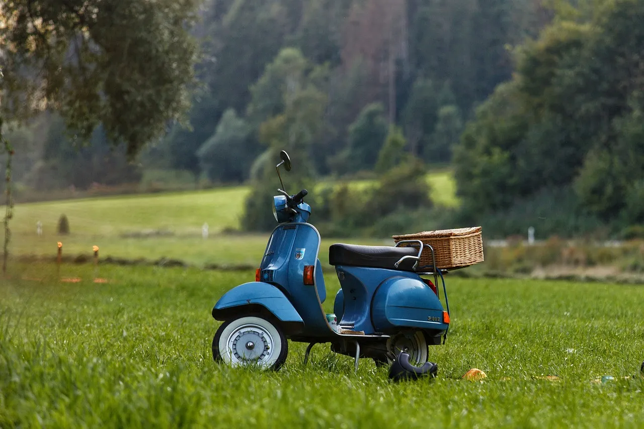moto azul parqueada en la zona verde uno de los lugares mas agradables en Italia.