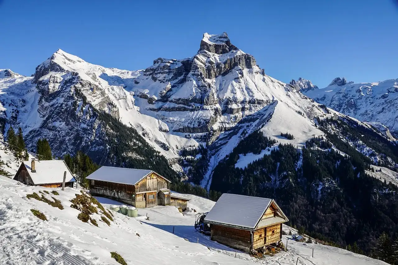 cabañas en montañas rocosas cubiertas de nieves, un lugar espectacular para disfrutar del invierno.