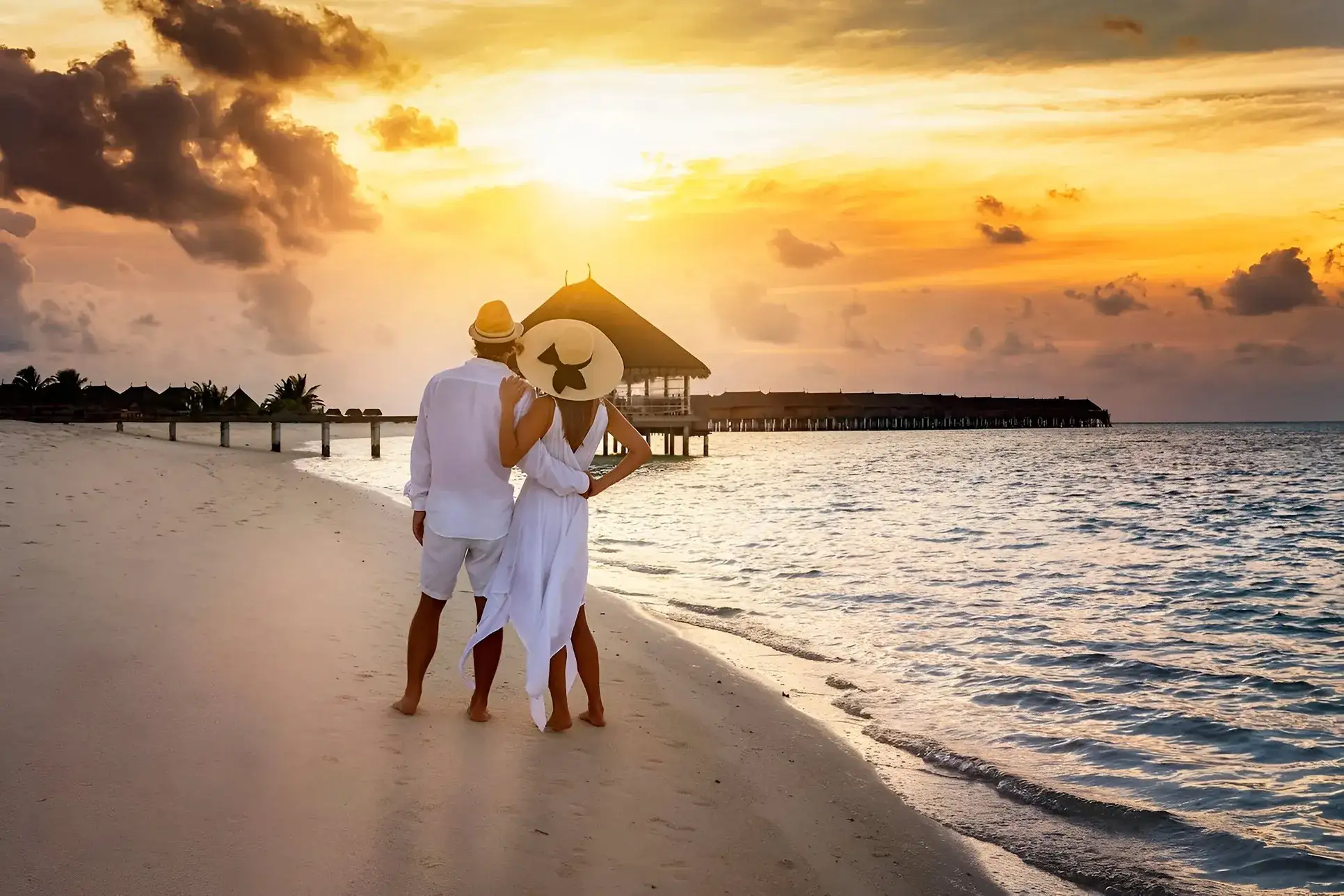 pareja en la playa admirando la vista del mar en el atardecer