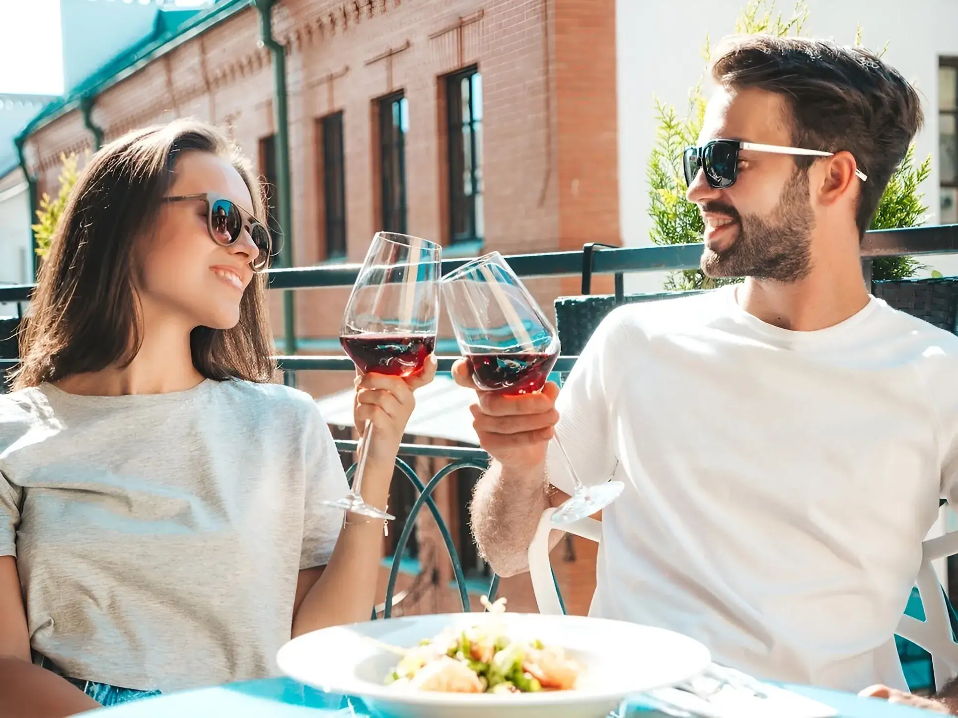 pareja haciendo un brindis de vino mientras degustan un delicioso platillo