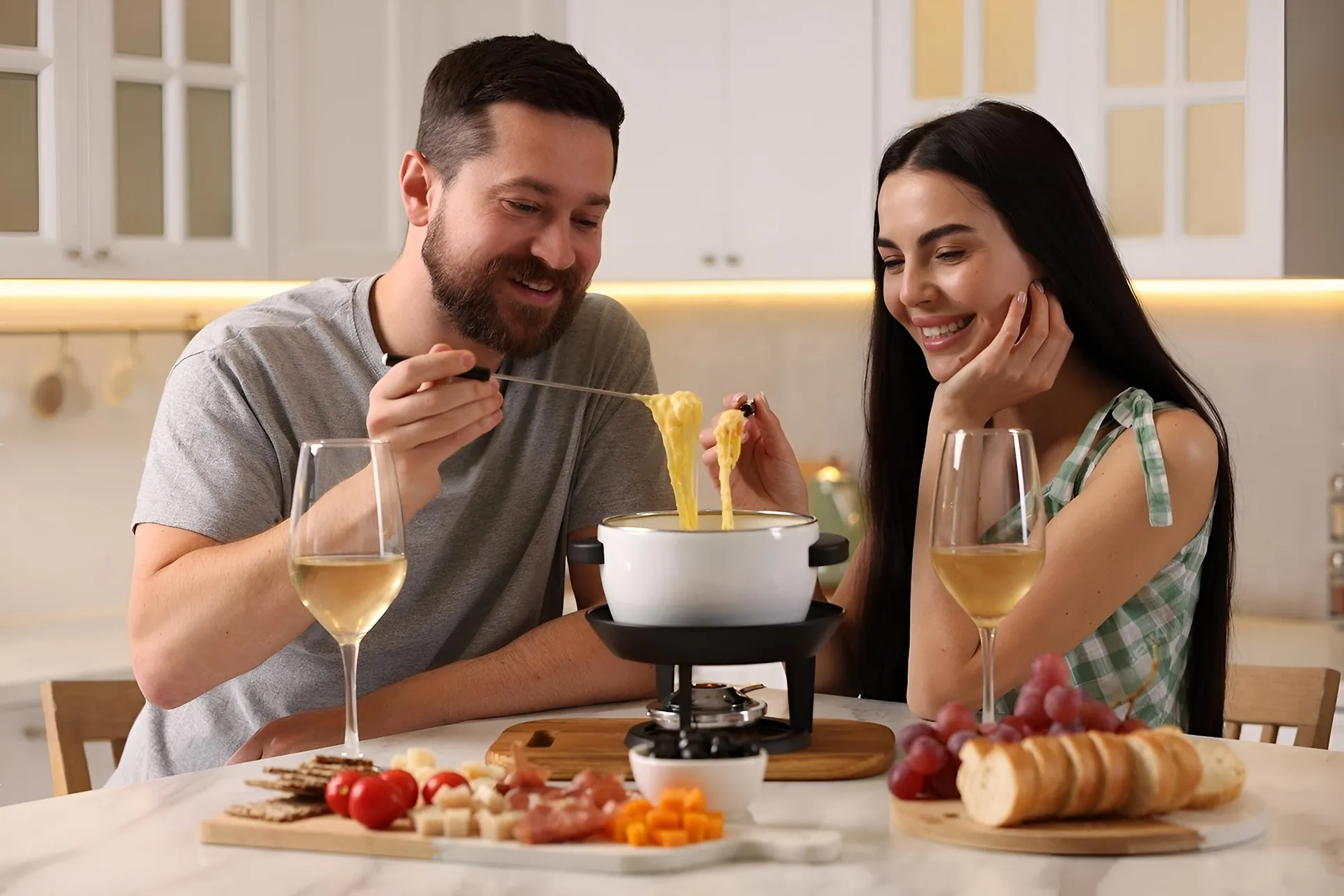 pareja disfrutando de uno delicioso fondas de queso junto a una copa de vino.