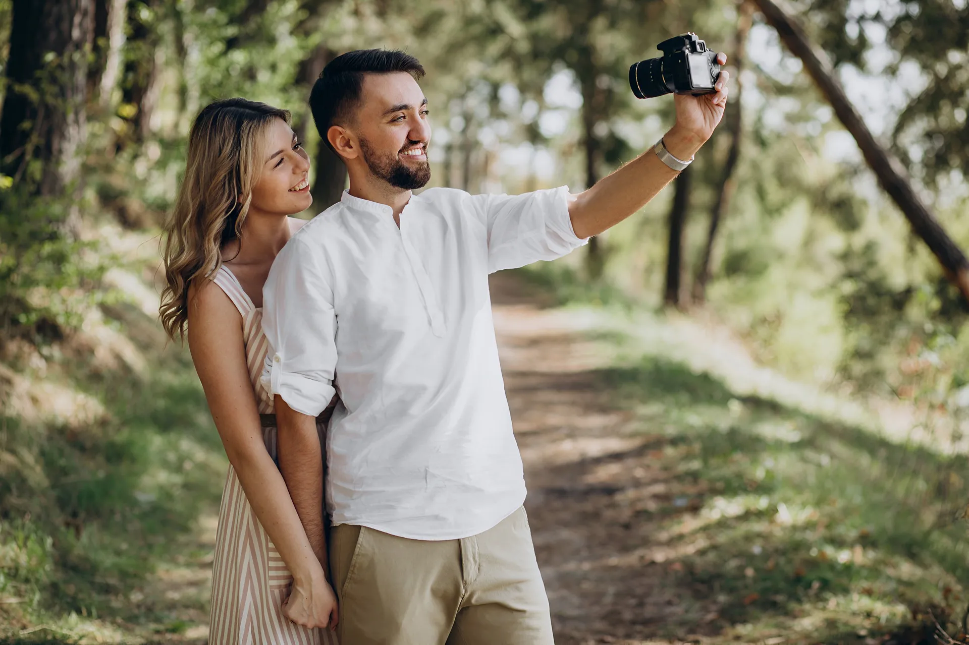 pareja tomándose una foto en medio del bosque, un lugar perfecto para capturar momento inolvidables.