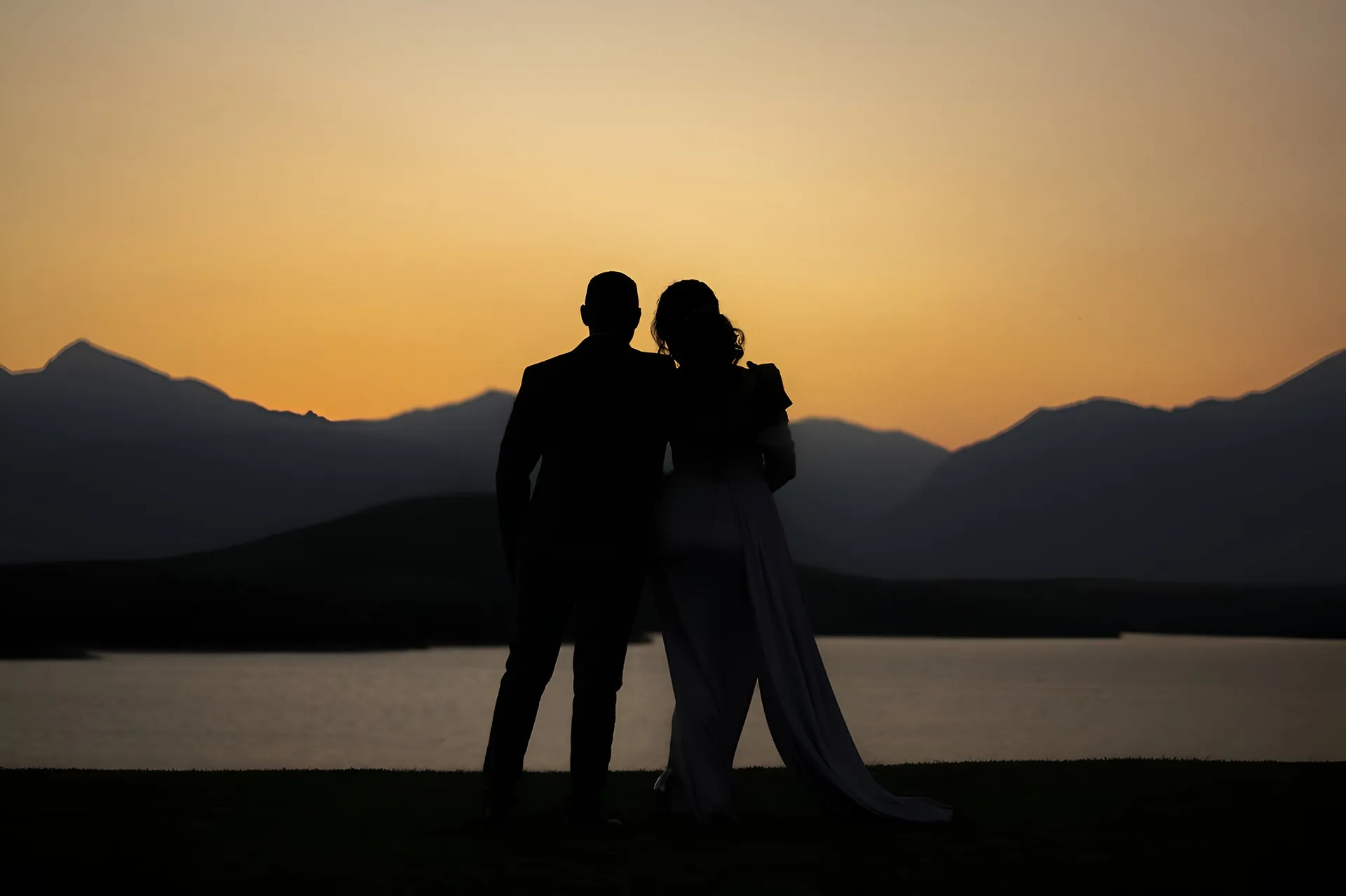 pareja admirando la vista al mar en el atardecer